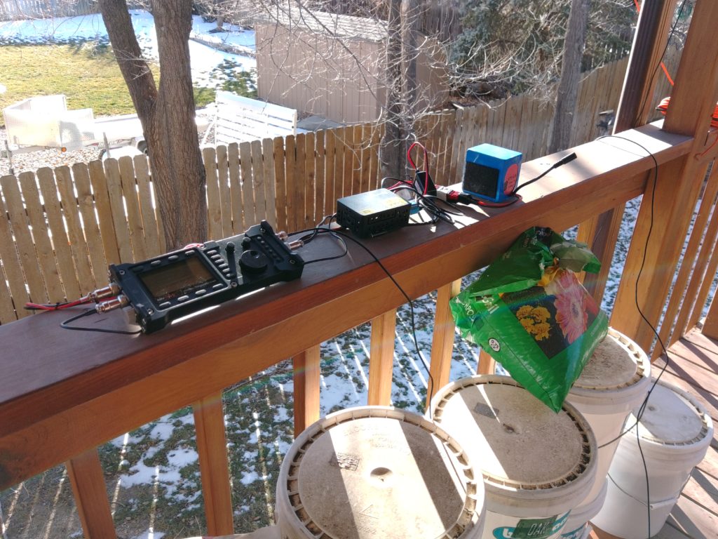 Radio, Raspberry Pi, and a 4.5Ah Bioenno battery pack connected on a deck railing.