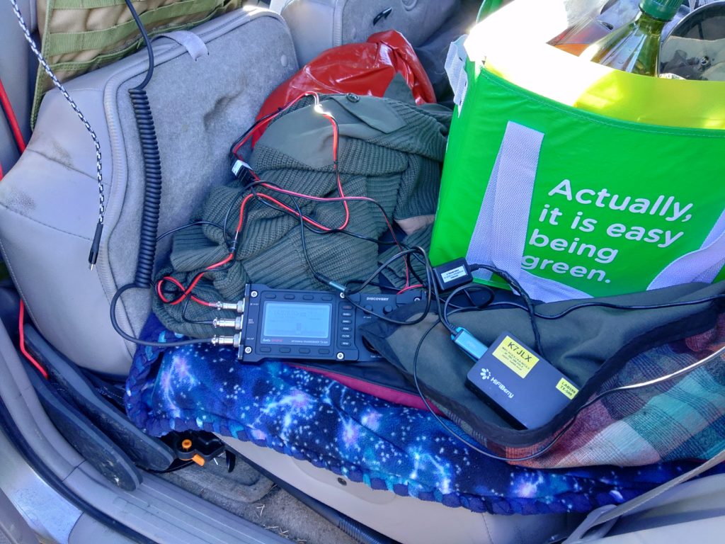A Raspberry Pi connected with a Lab599 TX-500 radio via two cables sitting in the back of a 4Runner.